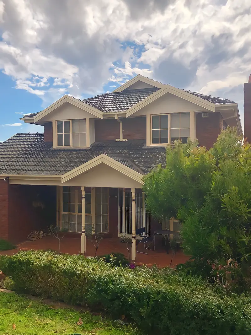 Double-storey home with tiled roof and new gutters