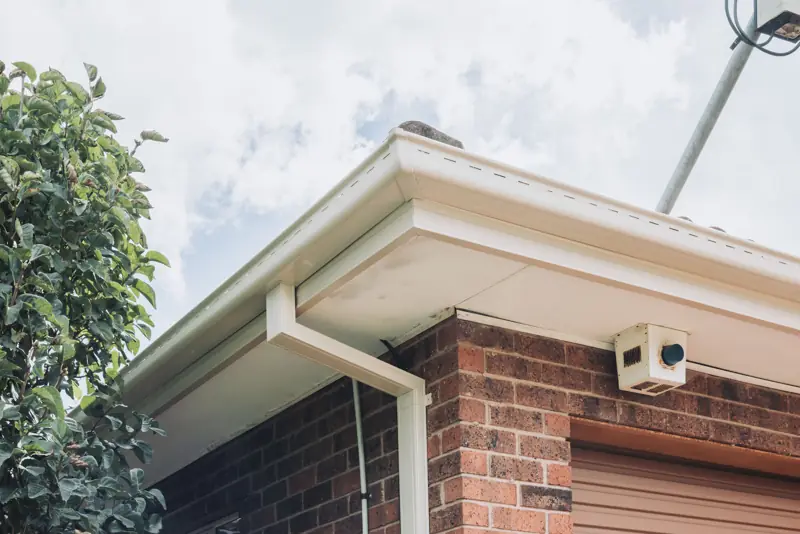 Corner of a home with new gutter and downpipe